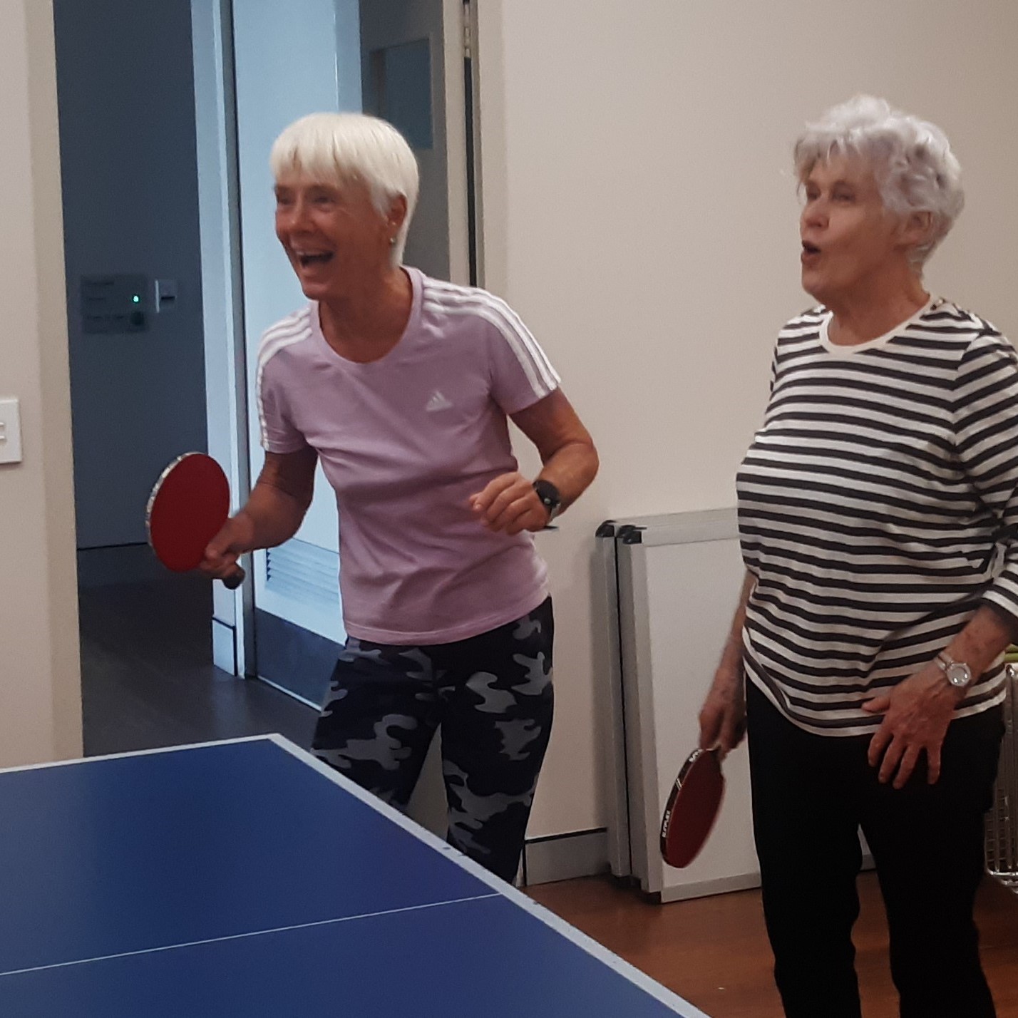 Two women playing table tennis